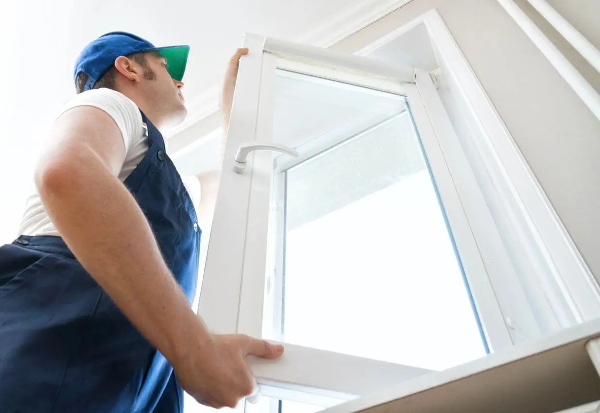 Professional Handyman Installing Window at Home